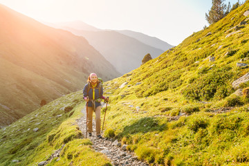 happy woman walking with backpack in pyrenees mountains highlands