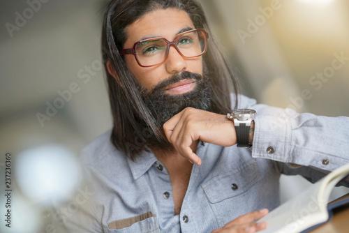Fotografie, Tablou Dark-haired man with eyeglasses reading book