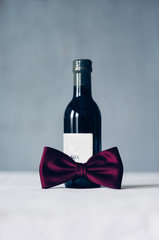 Wall Mural - Bottle of red wine decorated with red bow tie 