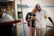 © Erickson Stock - Mature adult woman resting her head on the shoulder of her husband while holding wine glasses on a deck.