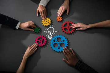 Business team connect pieces of gears to build a new creative idea. Teamwork, partnership and integration concept