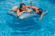 © Cindy Prins/Stocksy - Kids resting on an inflatable stingray in a swimming pool
