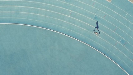 Wall Mural - Sports woman running on racetrack. Female runner sprinting on the cruves on athletics race track.