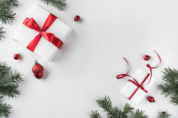 christmas gift boxes on white background with fir branches, pine cones, red ribbon. xmas and happy n