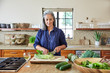 © Trinette Reed/Stocksy - Mature woman preparing a healthy salad in the kitchen at home