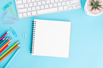 Wall Mural - blank notebook with keyboard and pencil on blue background,flat lay photo of notebook for your messa