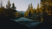 Beautiful View From Behind Car Steering Wheel, Driving Down The Mountain Woods Road In Sunset Yosemite Park Slow Motion.