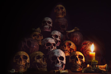 Wall Mural - Pile of Skulls and bones Lighting by candlelight / Still Life Image and dim light and adjustment color for background
