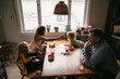 © Rob and Julia Campbell/Stocksy - Real family dinner with mom, baby, busy kids and normal food