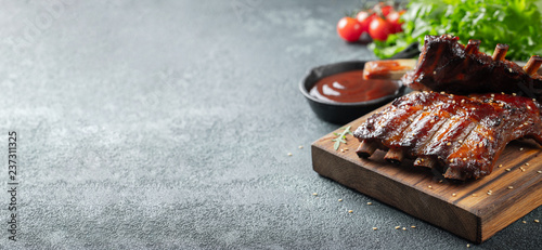 zblizenie-zeberka-wieprzowe-z-grilla-z-sosem-bbq-i-karmelizowane-w-miodzie-smakowita-przekaska-piwo-na-drewnianej-desce-dla-segregowac-na-zmroku-betonu-tle-z-miejscem-na-kopie