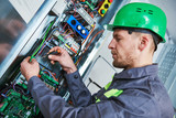 Fototapeta  - Electrician make maintenance in engine room of elevator