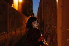 Sad Woman With Smartphone Near Wall