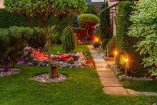 Garden Illuminated By Lamps In Evening