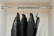 © Lyuba Burakova/Stocksy - Outwear on a rail in a wardrobe