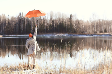 Wall Mural - winter walk with an umbrella / man in a coat with an umbrella, walk against the backdrop of the winter landscape, winter view