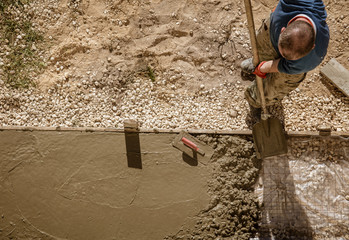 Workers pour concrete solution at a construction site