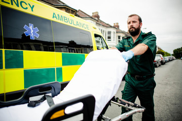 Wall Mural - Male paramedic moving the ambulance stretcher