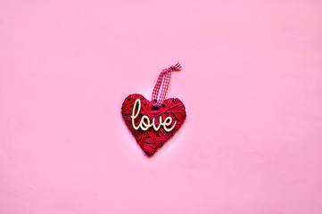 Wall Mural -  Love or Valentines Day concept. Creative paper background with wicker heart. Pink trendy color.Holiday and celebration concept for postcard or invitation. Top view, copy space, closeup.