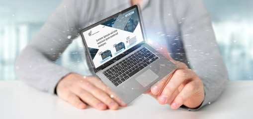 Poster - Businessman holding a Laptop with business website template on the screen isolated on a background