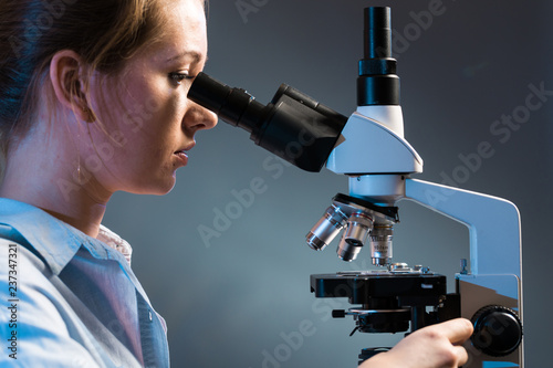 Fotografie, Obraz beautiful science student looking into a microscope in a laboratory