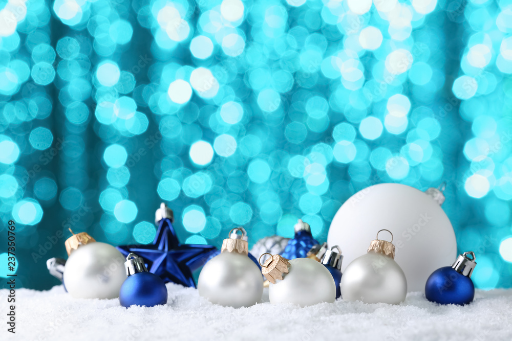 Christmas baubles on snow against blurred lights