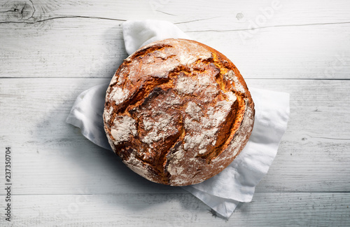 Fotografía Rustikales Brot auf weißem Tuch mit weißem Holzuntergrund
