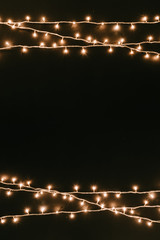 christmas tree lights on dark table top. rustic new year black minimal background with copy space. f