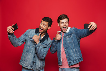 Canvas Print - Two cheerful young men standing isolated over red