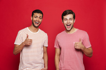 Canvas Print - Two cheerful young men standing isolated over red