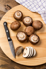 Wall Mural - fresh and sliced chestnut mushroom on a wooden board