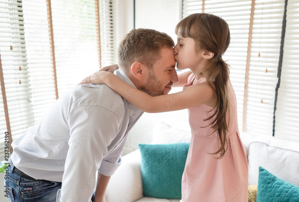 Happy family and father's day. Portrait of a little girl kissing her ...