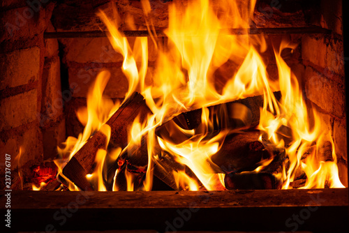 Burning Firewood In The Fireplace In The House Giving Heat And
