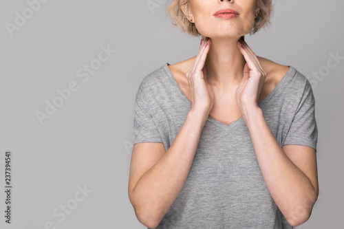 Fotomural Female checking thyroid gland by herself