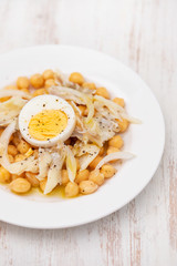 Sticker - chick-pea with cod fish and boiled egg on white plate