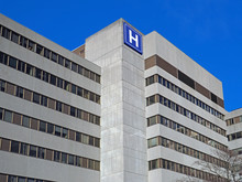 Large Concrete Building With  H Sign For Hospital