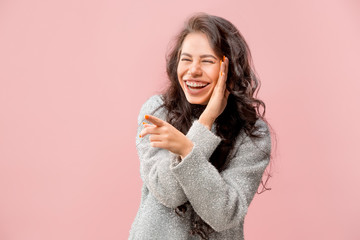 Secret, gossip concept. Young woman whispering a secret behind her hand. Business woman isolated on trendy pink studio background. Young emotional woman. Human emotions, facial expression concept.