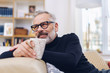 © contrastwerkstatt - Middle-aged man relaxing in his living room
