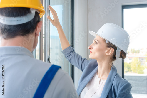 Fotografía Architect woman and construction worker checking windows on site