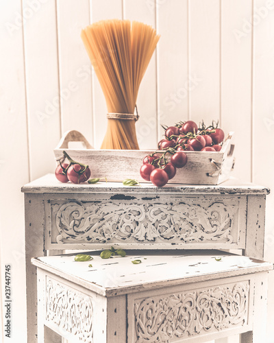 Fotovorhang - Tomatoes and basil in a white shabby chic decoration (von Fischer Food Design)