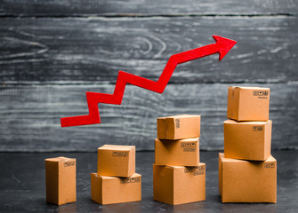 a red arrow up above cardboard boxes folded incrementally. Sales growth and increase in exports of goods and services. Growth profits and the number of buyers.