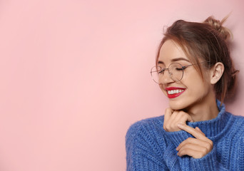Wall Mural - Beautiful young woman in warm sweater on color background. Space for text