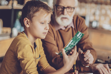 Wall Mural - Serious boy examining electronic chip