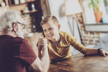 Wall Mural - Pleased boy competing with his grandfather