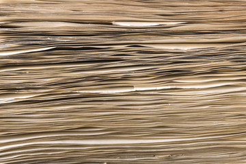 Side view of stack of old yellowed paper, closeup view.