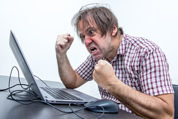 the angry user is screaming to the laptop. aggressive man working with notebook at office. system er