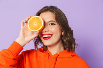 Wall Mural - Beautiful young woman posing isolated over purple background wall.