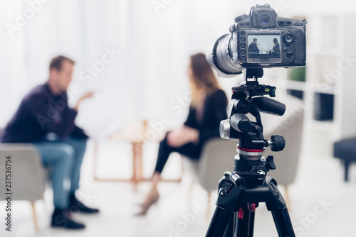 Cuadros en Lienzo businesswoman in suit giving interview to journalist in office, camera on tripod