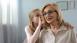 © motortion - Funny female grandkid whispering secret to beautiful grandmother, family trust