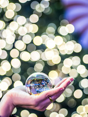 Wall Mural - crystal ball in hand lighting bokeh chirstmas background blur