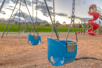 Wall Mural - Playground with baby swing and slide near homes